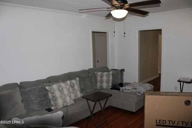 living area featuring dark wood-style floors, crown molding, and ceiling fan