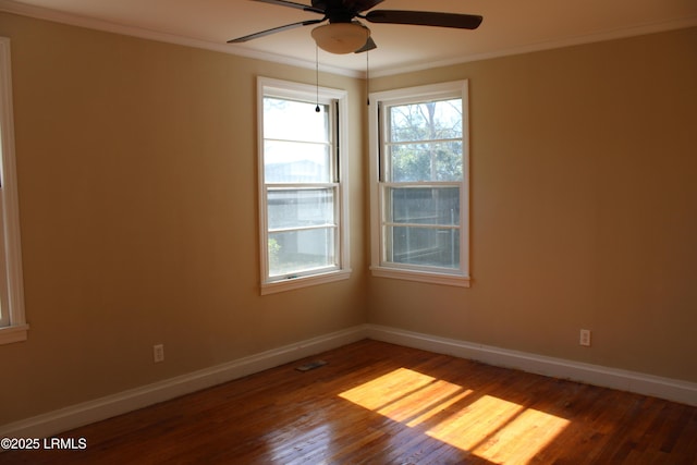 spare room with ornamental molding, ceiling fan, baseboards, and wood finished floors