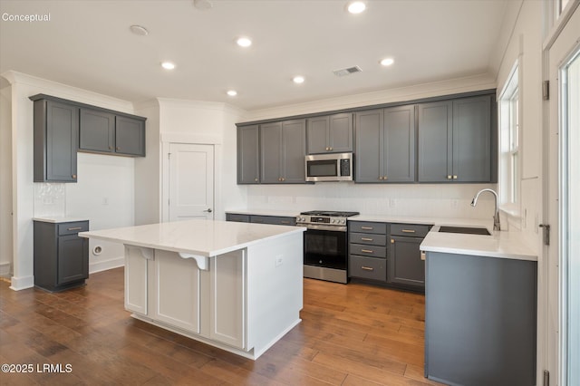 423 Parkside Commons, Bluffton, SC 29910 - kitchen with stainless steel appliances, ornamental molding, a center island, decorative backsplash, and dark wood-type flooring