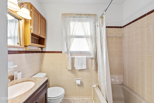 full bathroom with tile walls, shower / tub combo, vanity, and toilet