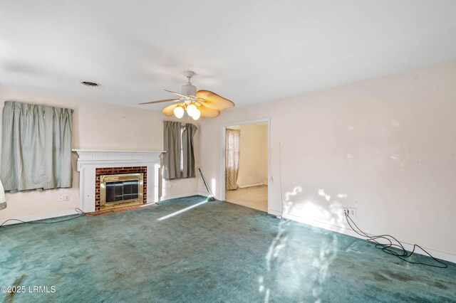 unfurnished living room with a brick fireplace, carpet flooring, and ceiling fan