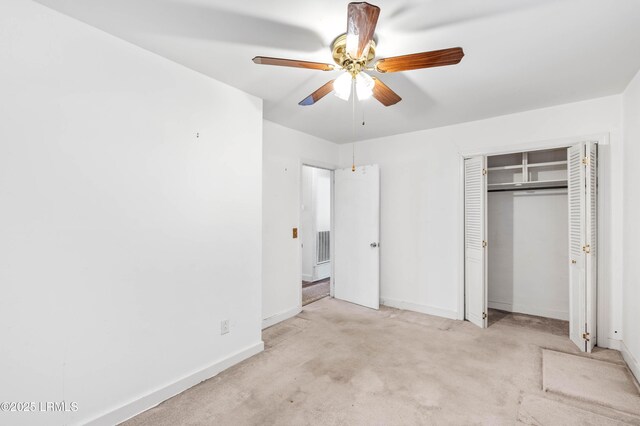 unfurnished bedroom featuring ceiling fan, light colored carpet, and a closet