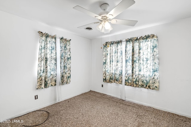 carpeted spare room featuring a healthy amount of sunlight and ceiling fan