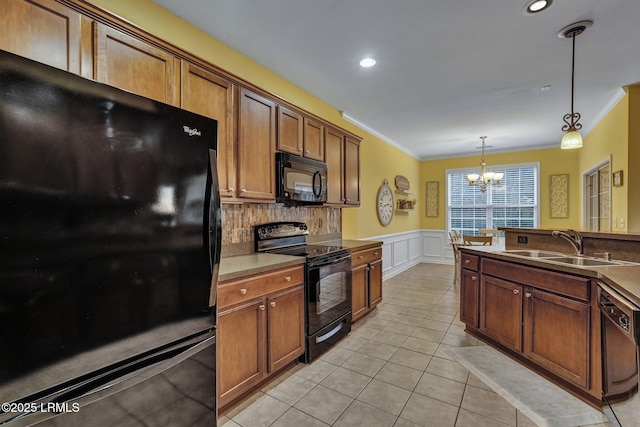 kitchen featuring black appliances, brown cabinets, a sink, and decorative light fixtures