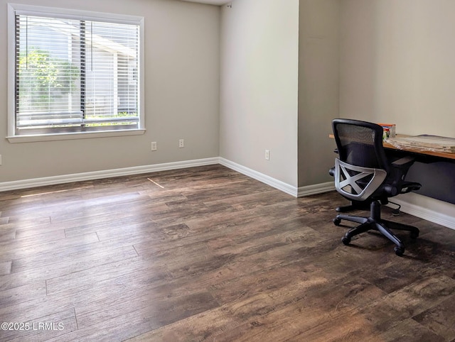 unfurnished office featuring wood finished floors and baseboards