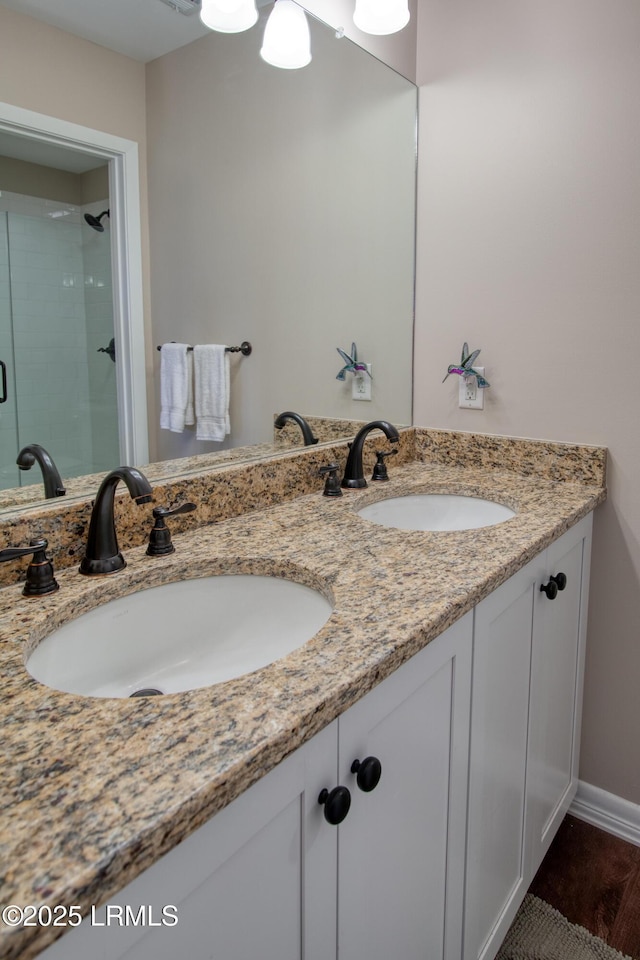 bathroom featuring double vanity and a shower stall