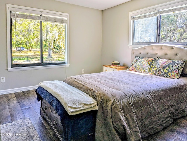 bedroom featuring hardwood / wood-style floors, multiple windows, and baseboards