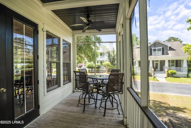 sunroom / solarium featuring outdoor dining space and ceiling fan