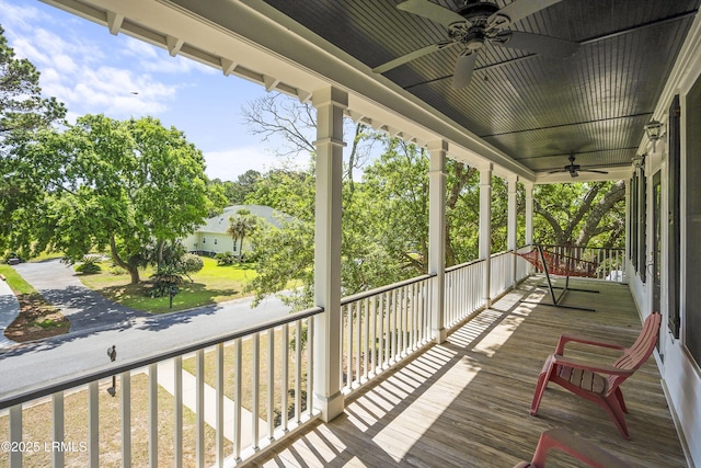wooden deck with a porch and ceiling fan