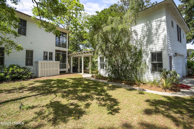 back of property featuring a garage and a lawn