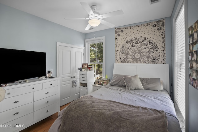 bedroom featuring visible vents, dark wood-style flooring, and ceiling fan