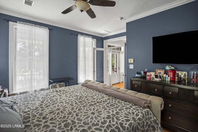 bedroom featuring ceiling fan, visible vents, and ornamental molding