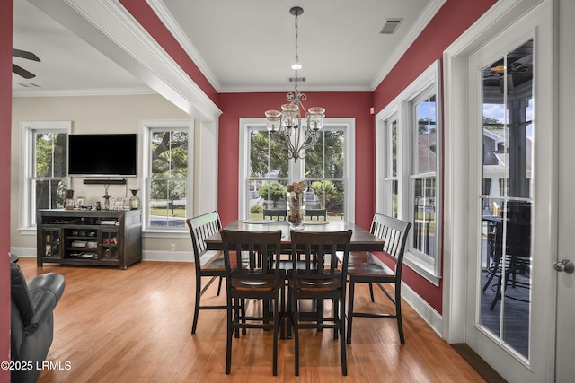 dining room with crown molding, visible vents, wood finished floors, and baseboards