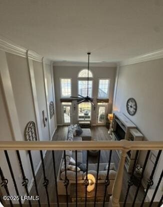 stairway with ornamental molding and wood finished floors