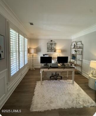 office featuring a wainscoted wall, crown molding, a decorative wall, and wood finished floors