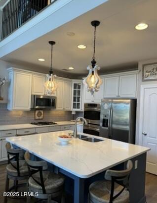 kitchen with dark wood-style floors, appliances with stainless steel finishes, a breakfast bar, and a sink