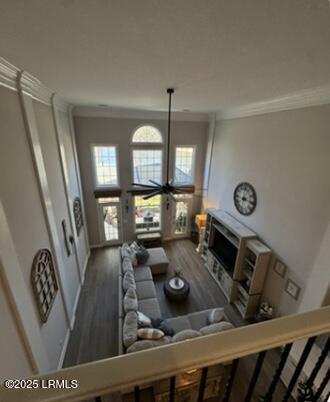 living room with a fireplace, crown molding, and wood finished floors