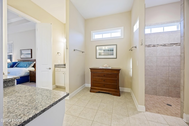 bathroom featuring vanity, tiled shower, and tile patterned floors