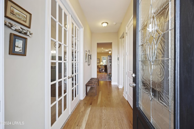 corridor with french doors and light wood-type flooring