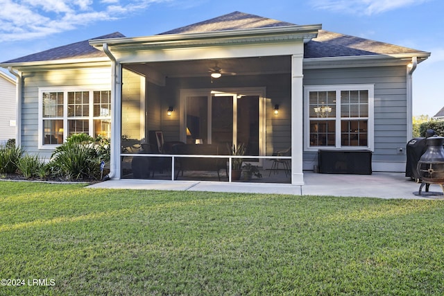 back of house with a patio, a sunroom, and a lawn