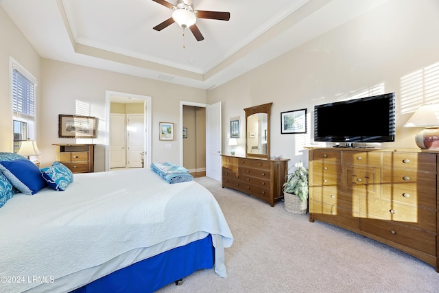 bedroom featuring ceiling fan, a raised ceiling, and light colored carpet