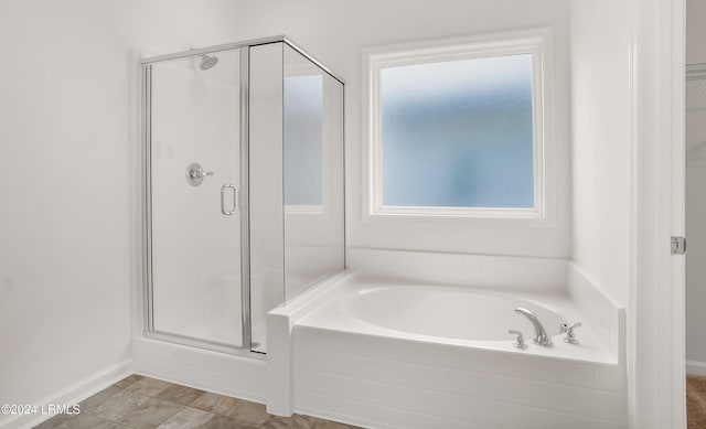 bathroom featuring independent shower and bath and a wealth of natural light