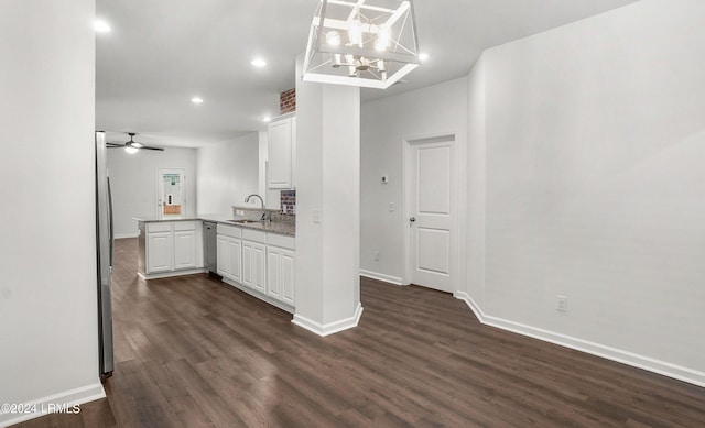 kitchen featuring sink, white cabinets, dark hardwood / wood-style flooring, decorative light fixtures, and kitchen peninsula