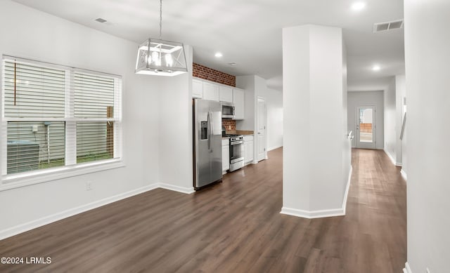 kitchen featuring dark hardwood / wood-style floors, pendant lighting, tasteful backsplash, white cabinets, and stainless steel appliances