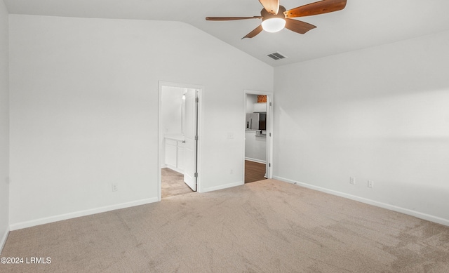 unfurnished bedroom featuring ceiling fan, lofted ceiling, connected bathroom, and light colored carpet