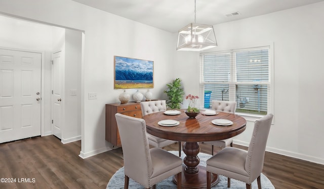 dining room with dark hardwood / wood-style flooring and a notable chandelier