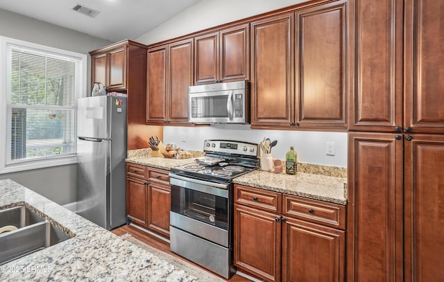 3010 Palmetto Ridge St, Beaufort, SC 29906 - kitchen featuring visible vents, light wood-style floors, vaulted ceiling, light stone countertops, and stainless steel appliances