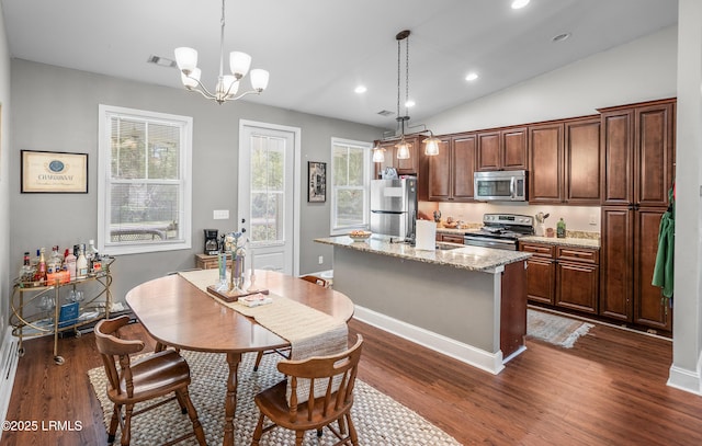 3010 Palmetto Ridge St, Beaufort, SC 29906 - kitchen featuring a notable chandelier, decorative light fixtures, dark wood-style flooring, appliances with stainless steel finishes, and a center island with sink