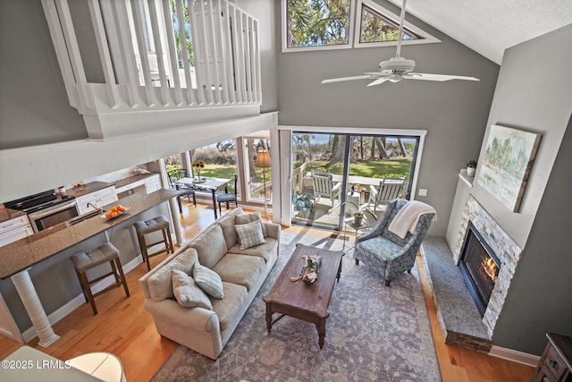 2009 Bluff Villas Rd, Saint Helena Island, SC 29920 - living room with a fireplace, high vaulted ceiling, plenty of natural light, ceiling fan, and wood finished floors