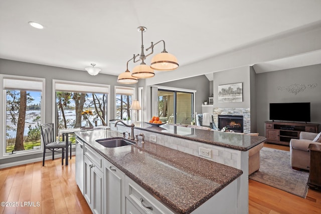 2009 Bluff Villas Rd, Saint Helena Island, SC 29920 - kitchen featuring a center island with sink, a sink, white cabinets, dark stone countertops, and recessed lighting