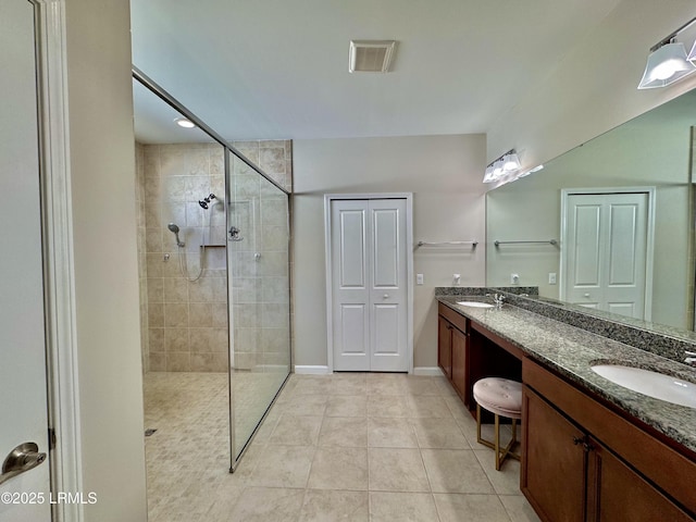 bathroom featuring a sink, tile patterned flooring, visible vents, and walk in shower