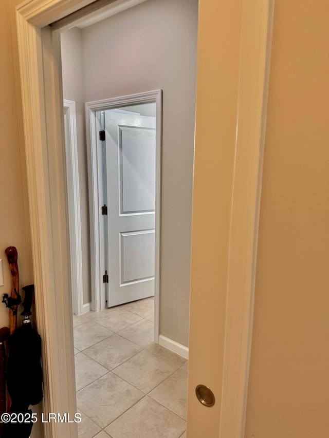 hall with light tile patterned floors and baseboards