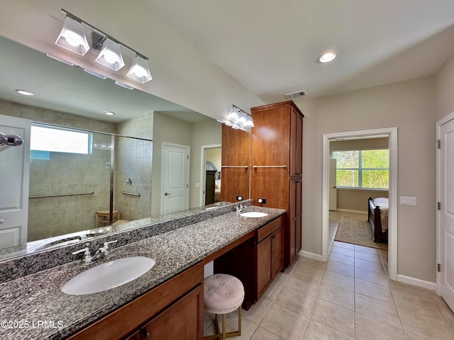bathroom with tiled shower, visible vents, a sink, tile patterned floors, and double vanity