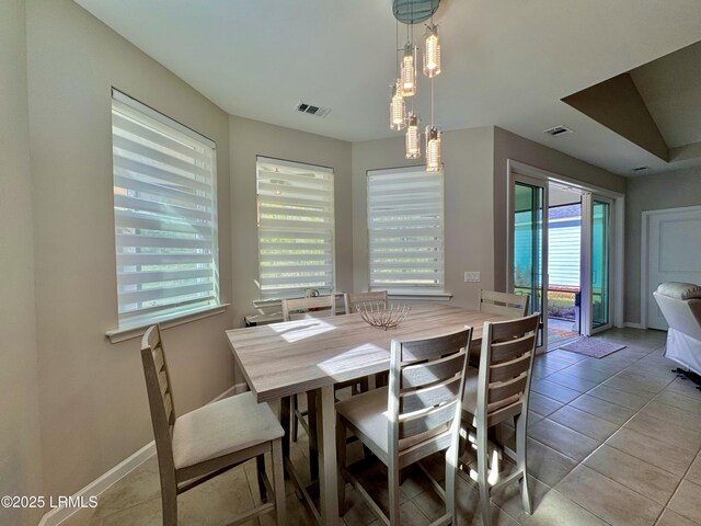 dining area featuring light tile patterned floors, baseboards, and visible vents