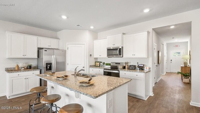 184 Twickenham Loop, Yemassee, SC 29945 - kitchen with stainless steel appliances, dark wood-type flooring, a breakfast bar, white cabinets, and light stone counters