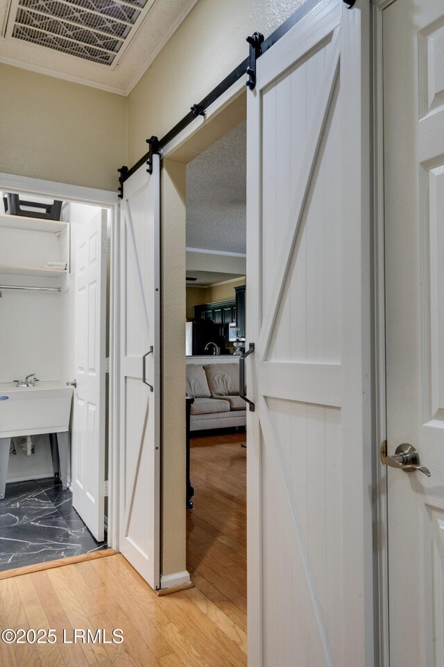 bathroom featuring visible vents, a sink, crown molding, and hardwood / wood-style floors