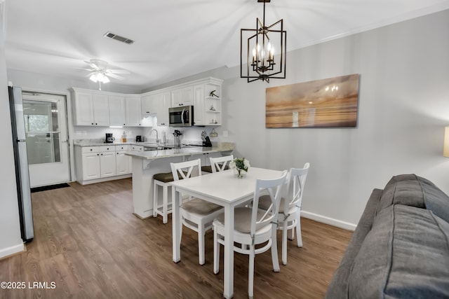 dining area with hardwood / wood-style flooring, ceiling fan, and sink