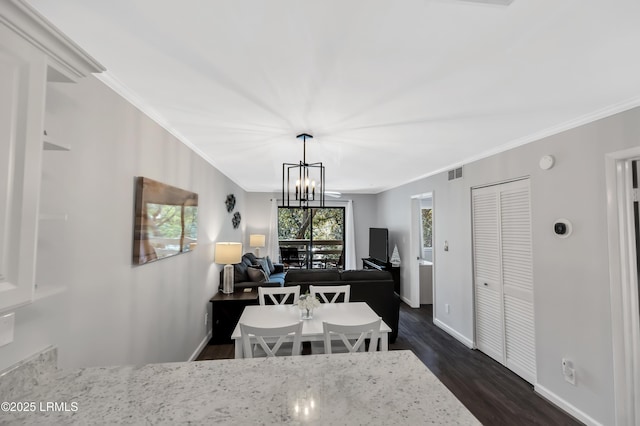 dining space featuring crown molding, dark hardwood / wood-style flooring, and a chandelier