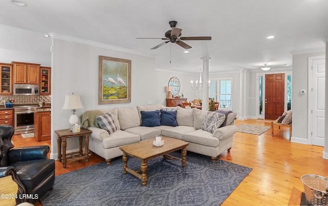 living room featuring crown molding, ceiling fan with notable chandelier, decorative columns, and light wood-type flooring