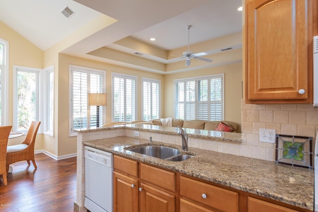 kitchen with tasteful backsplash, dishwasher, sink, dark hardwood / wood-style flooring, and light stone countertops