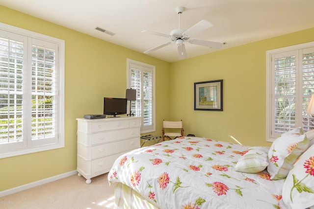 carpeted bedroom featuring multiple windows and ceiling fan