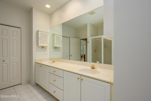 bathroom with tile patterned floors, a shower with shower door, and vanity