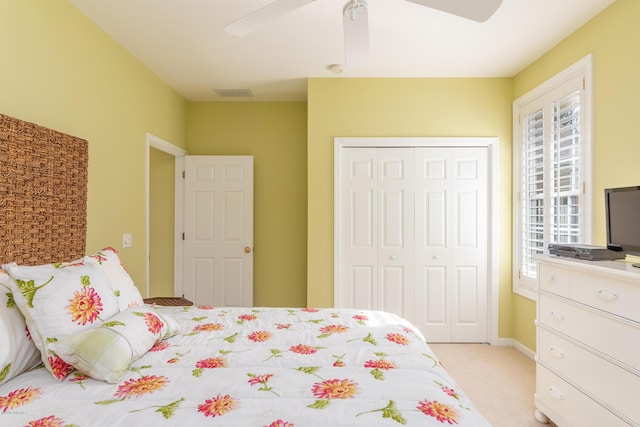 carpeted bedroom featuring ceiling fan and a closet