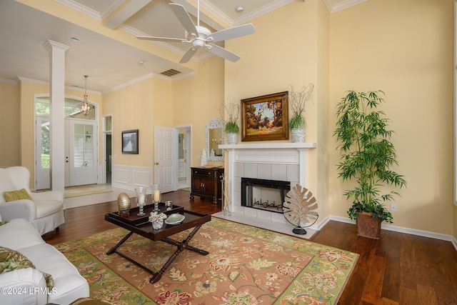 living room featuring ornamental molding, dark hardwood / wood-style floors, ceiling fan, and a fireplace