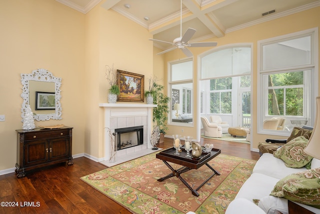 living room with coffered ceiling, dark hardwood / wood-style floors, a tile fireplace, and beamed ceiling