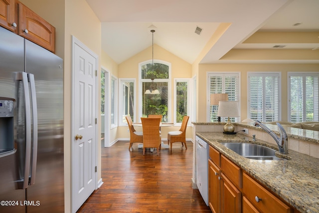 kitchen with sink, dishwasher, hanging light fixtures, light stone countertops, and stainless steel fridge with ice dispenser